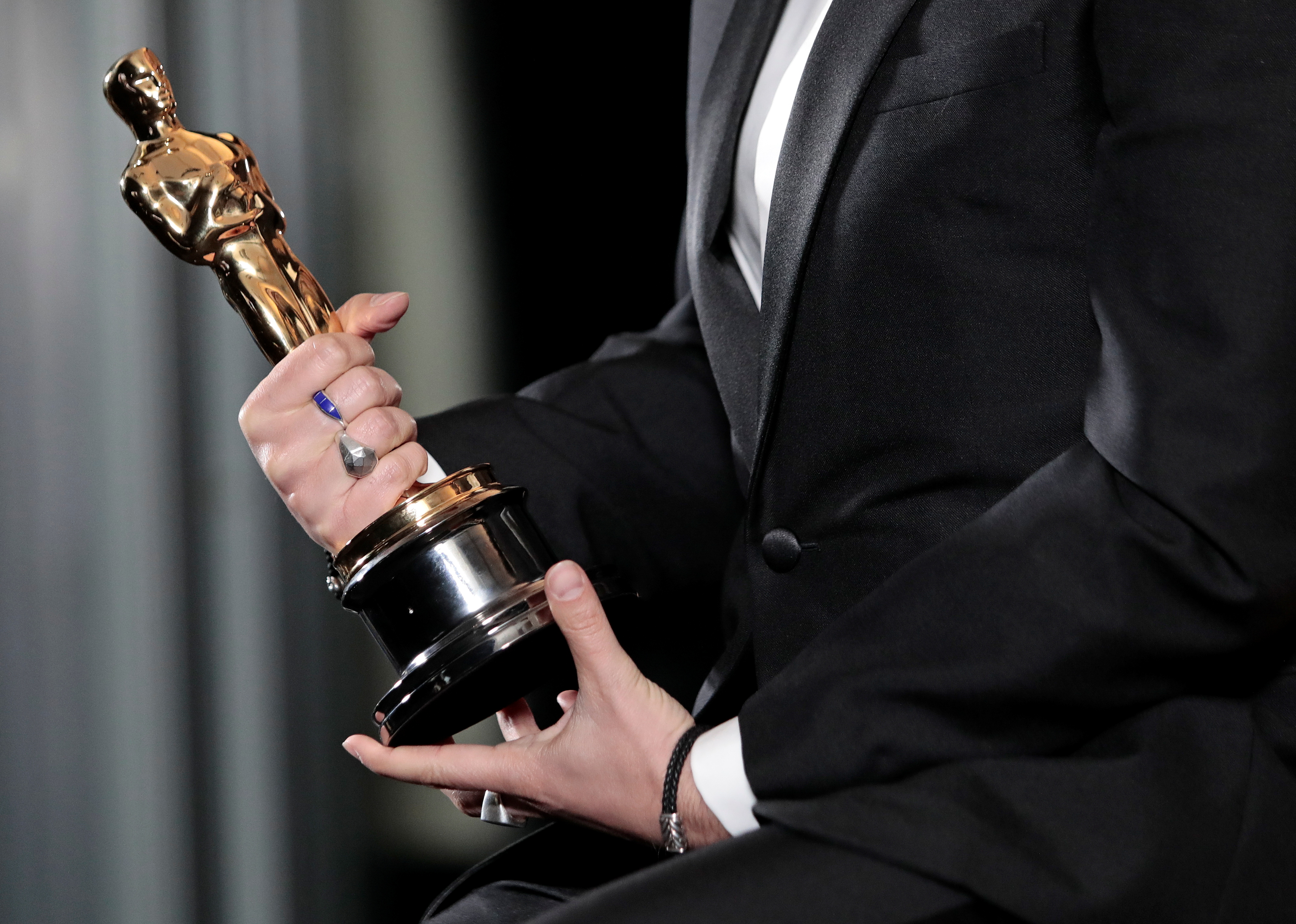 Florian Zeller holds his Oscars statuette after winning the Best Adapted Screenplay for the "The Father" at a screening of the Oscars in Paris, France April 26, 2021. Lewis Joly/Pool via REUTERS